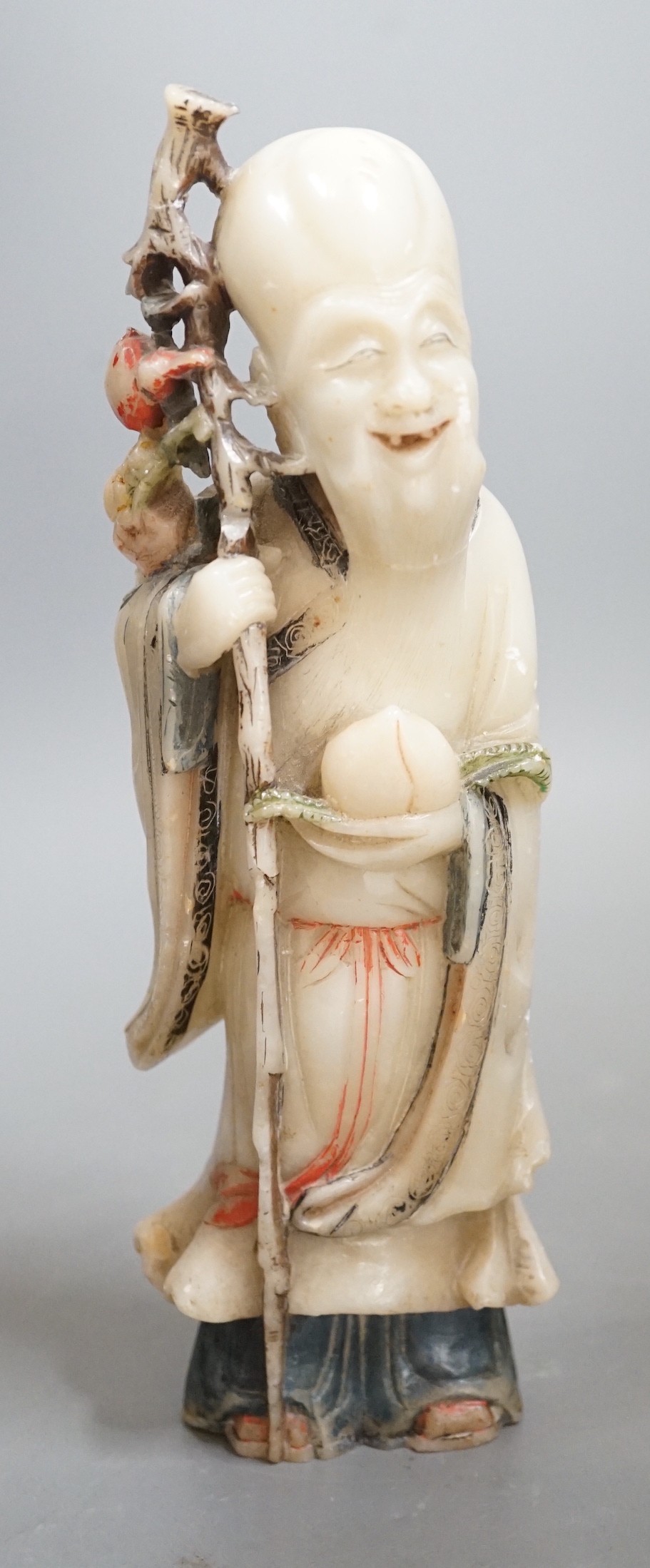 An 18th century Chinese carved soapstone figure of Shao Lou on carved hardwood stand. 24cm high (a.f.)